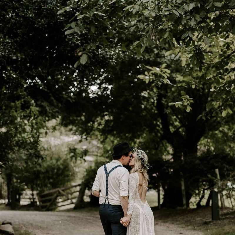 Bride in low back lace wedding dress with Protea bouquet