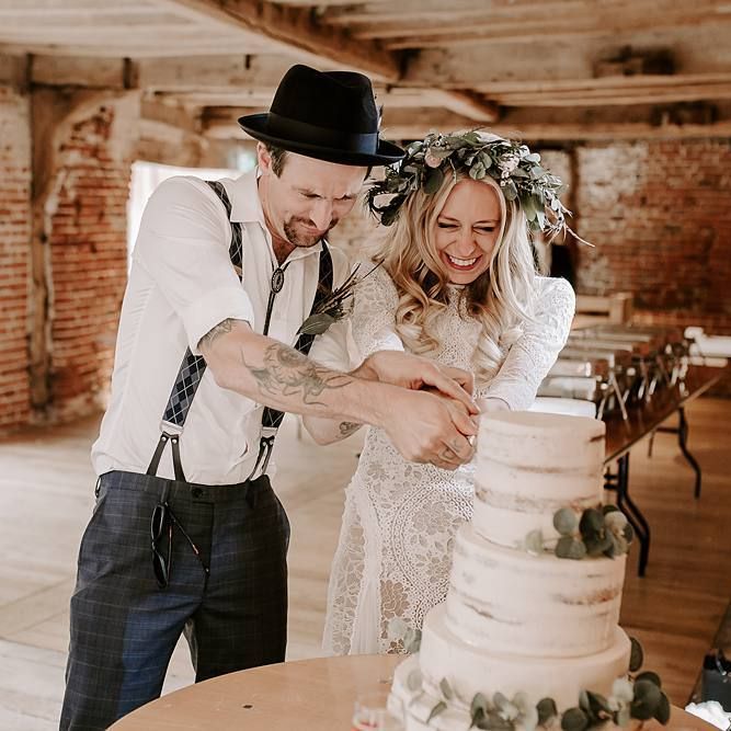Bride and groom cut the rustic wedding cake