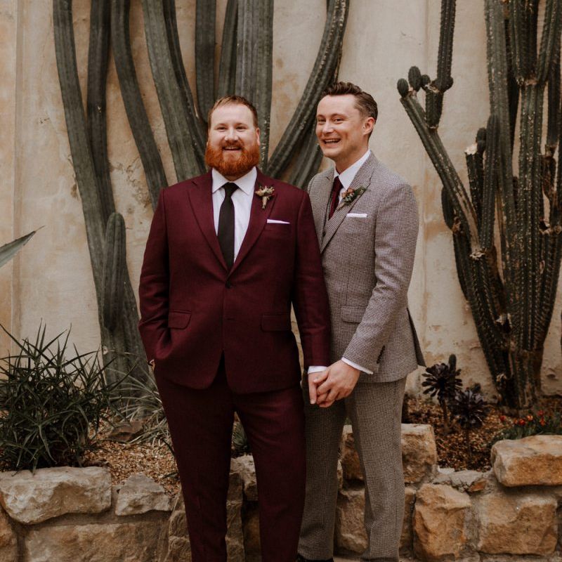 Same sex couple on burgundy and checked suits
