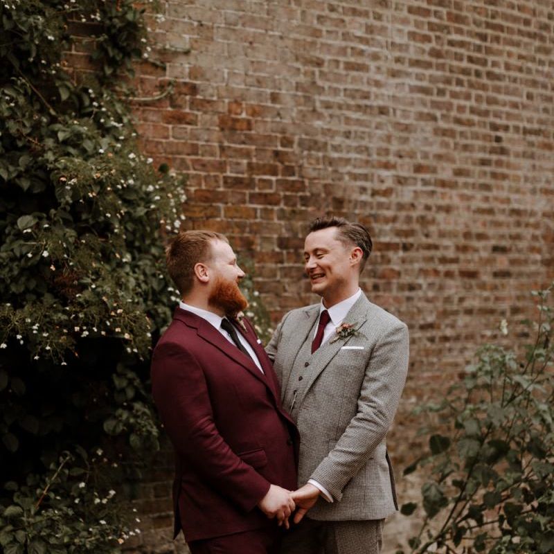 Portrait of groom in burgundy and beige checked suits at their Syon Park wedding