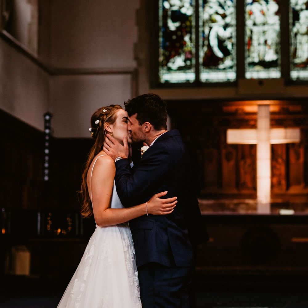 Bride and groom kiss during church wedding ceremony