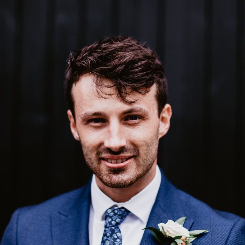 Groom in navy suit with patterned tie