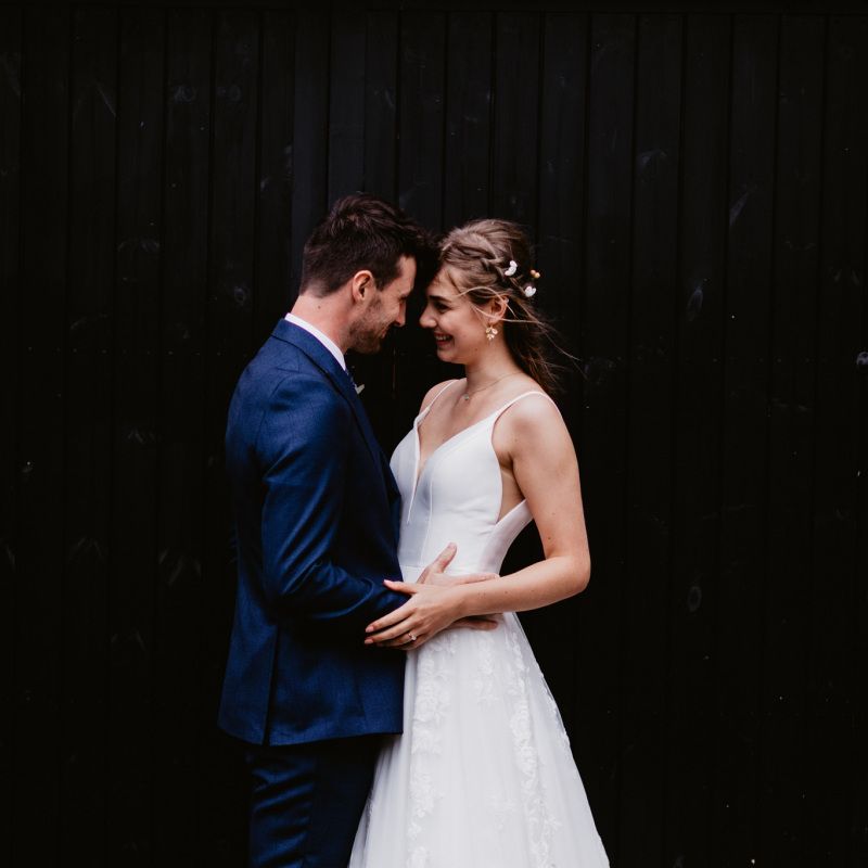 Bride in Essense of Australia wedding dress and groom in navy blue suit embracing