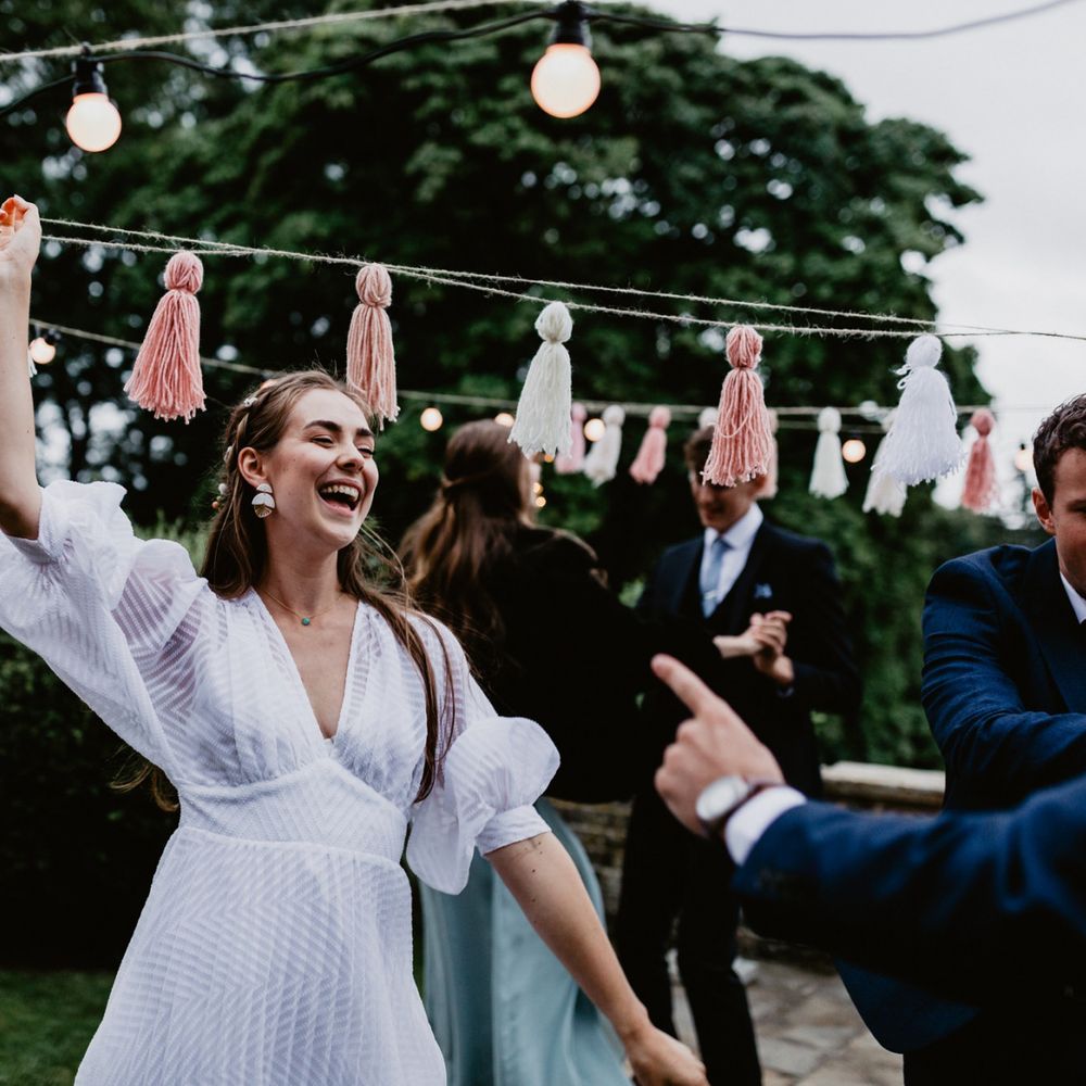 socially distanced wedding reception with festoon lights and tassels