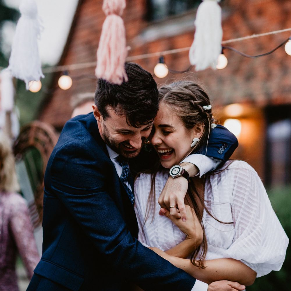 Bride and groom embracing at socially distanced wedding