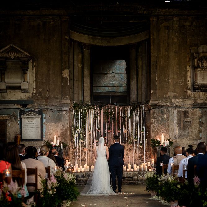 Bride and Bride Standing at The Asylum Altar with Candles and Hanging Ribbons