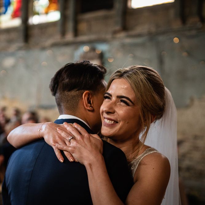 Wedding Ceremony at The Asylum with Bride in Navy Suit and Pink Tie and Bride in Romantic Flora Mila Wedding Dress Embracing at the Altar