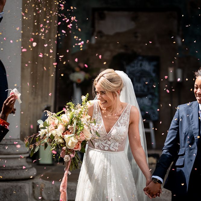 Confetti Moment with Bride in Navy Suit and Pink Tie and Bride in Romantic Flora Mila Wedding Dress