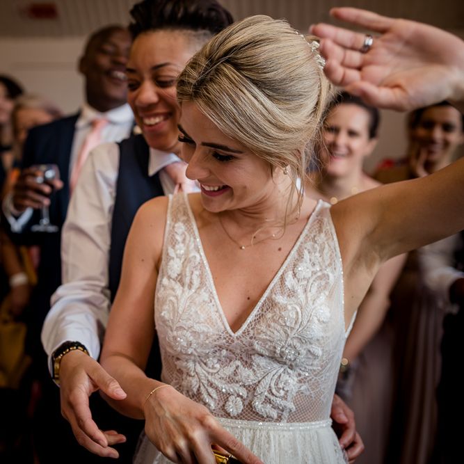 Bride in Flora Mila Wedding Dress and Bride in Navy Suit and Pink Tie Cutting the Wedding Cake Together