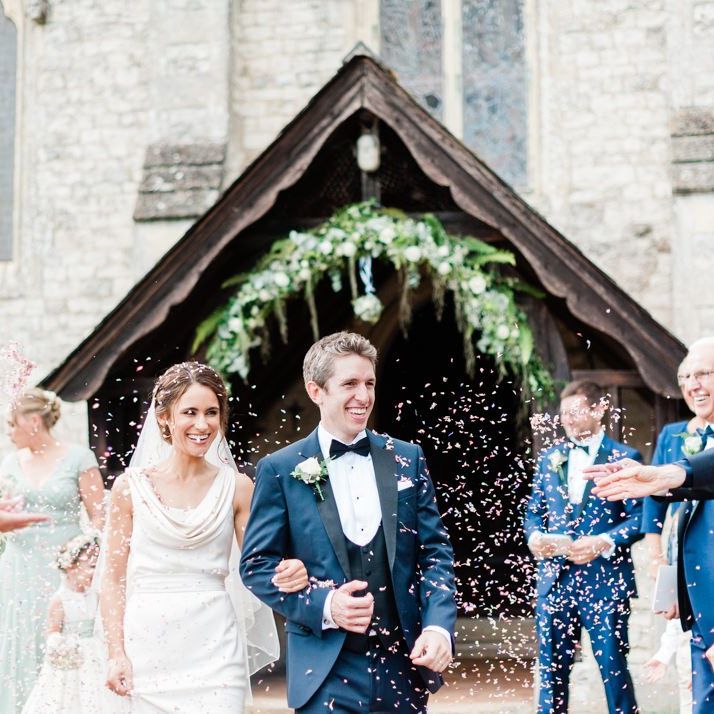 Confetti exit under flower arch at church