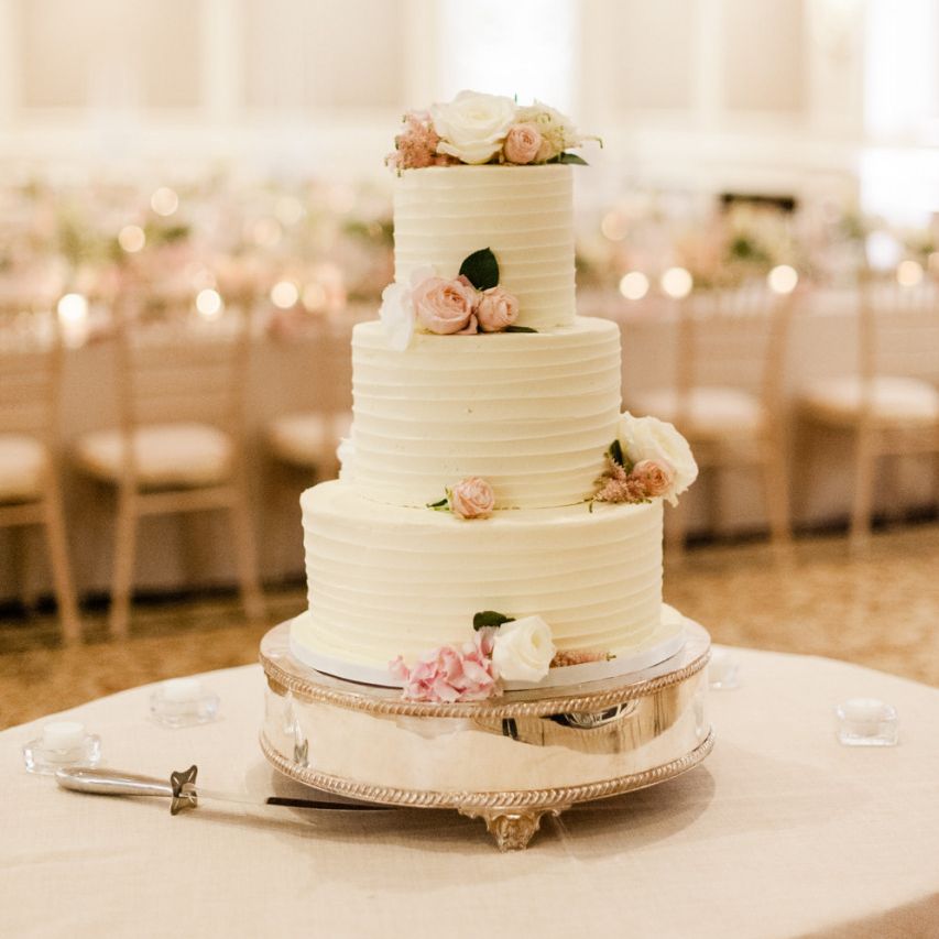 White wedding cake with pink flower decor