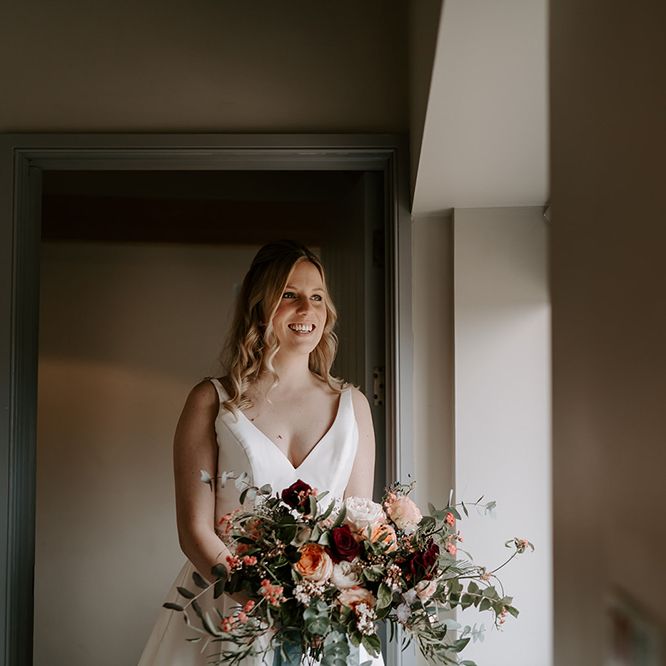 Bride in satin dress with large wedding bouquet
