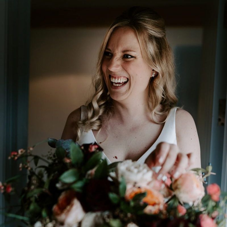 Bride with large bouquet during preparations for barn wedding