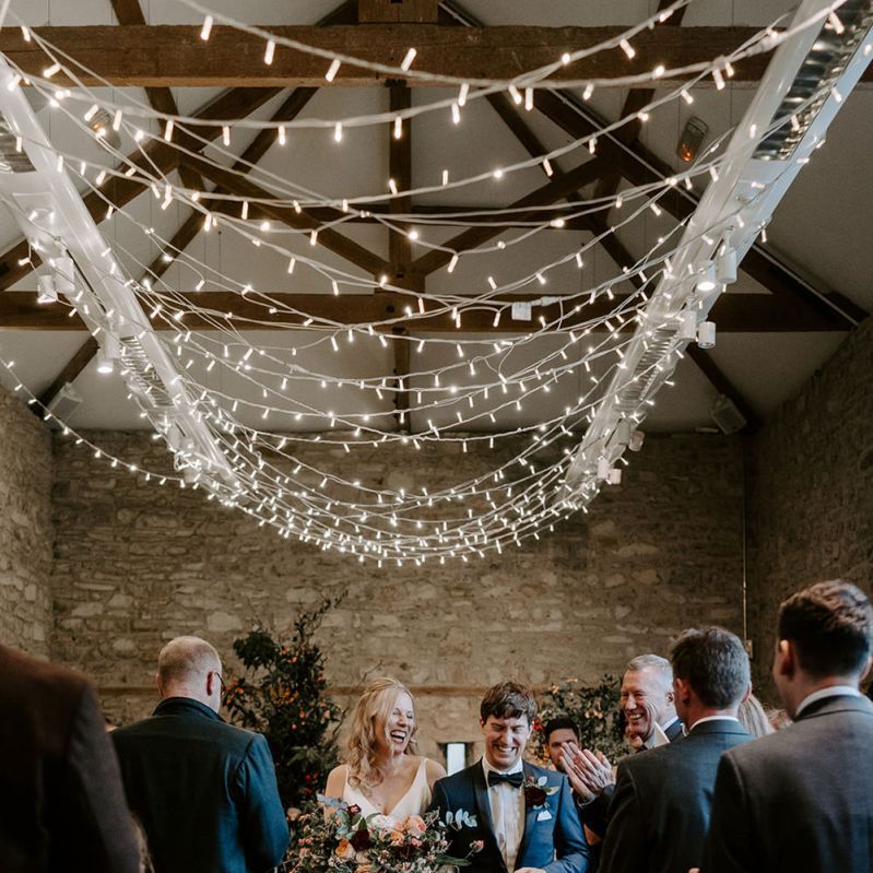 Bride and groom walk down the aisle at ceremony with unplugged wedding sign