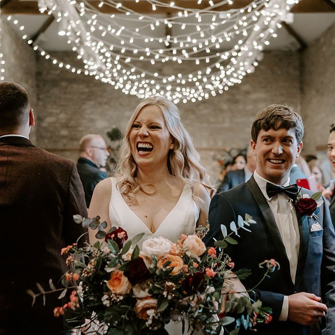 Newlywed bride and groom at ceremony with unplugged wedding sign