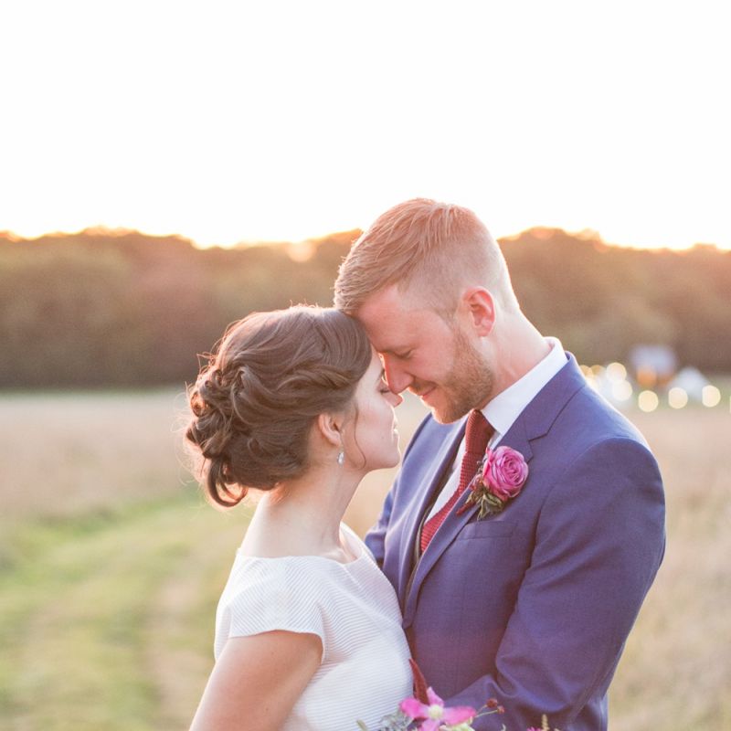 Bride in Jesus Peiro Wedding Dress and Groom in Blue  Hugo Boss Suit Embracing in the Countryside
