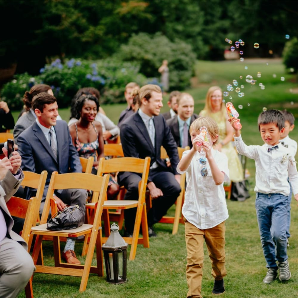 Page boys with bubbles walking down the aisle