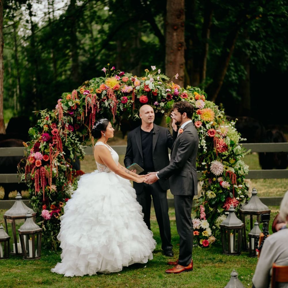 Outdoor civil ceremony in front of a flower arch