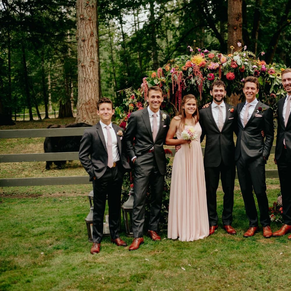 Groomsmen wedding party portrait in front of the flower arch