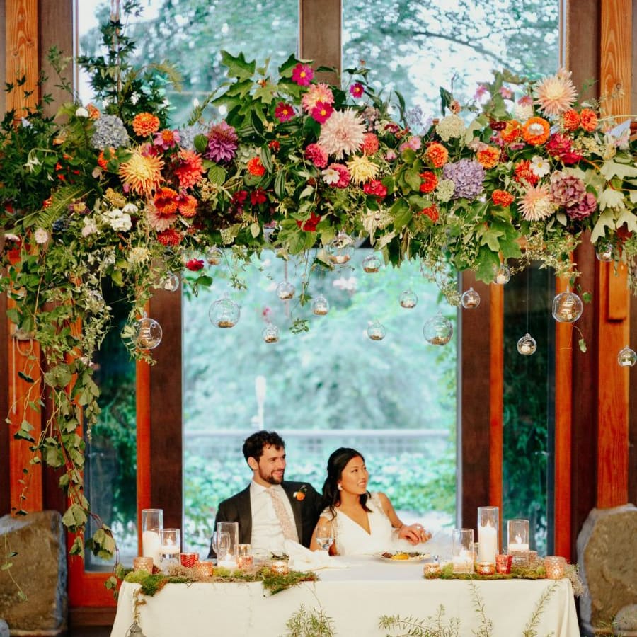 Bride and groom sitting at their sweetheart table