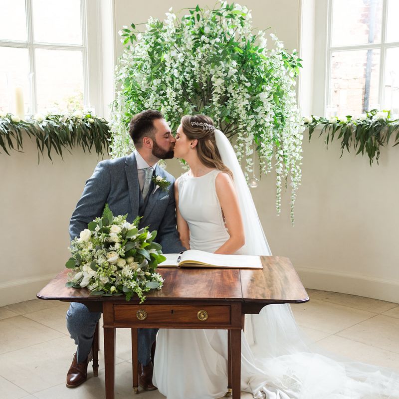Bride and Groom Sitting at the Altar Signing the Register