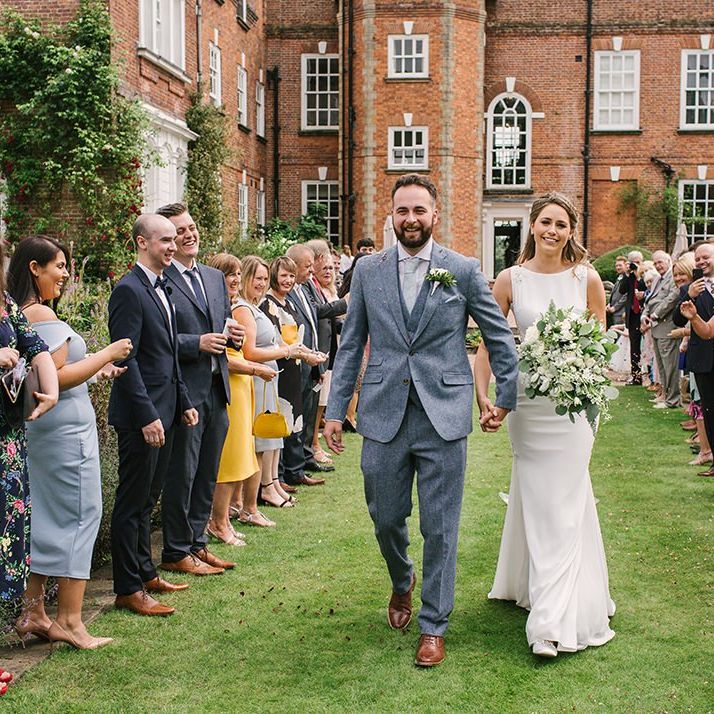 Confetti Moment with Bride in Pronovias Wedding Dress and Groom in Grey Suit