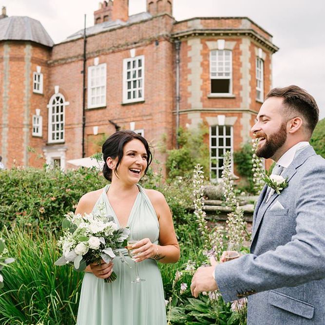 Groom in Grey Wedding Suit and Bridesmaids in Pale Green Multiway Dress Talking