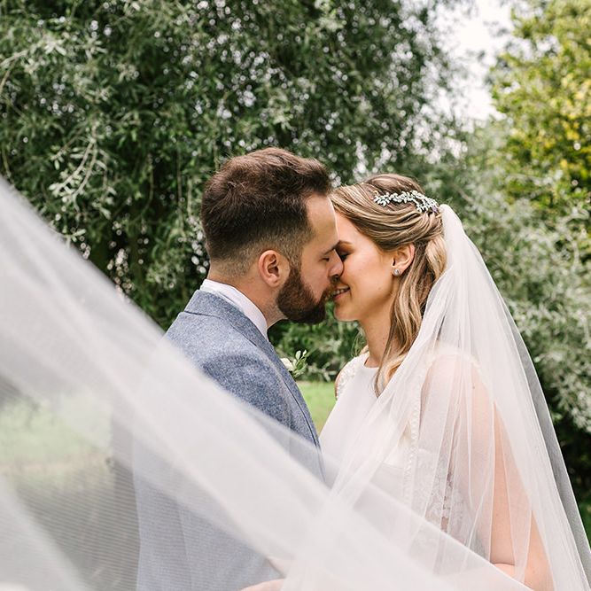 Bride and Groom Kissing with the Brides Veil Blowing in the Wind