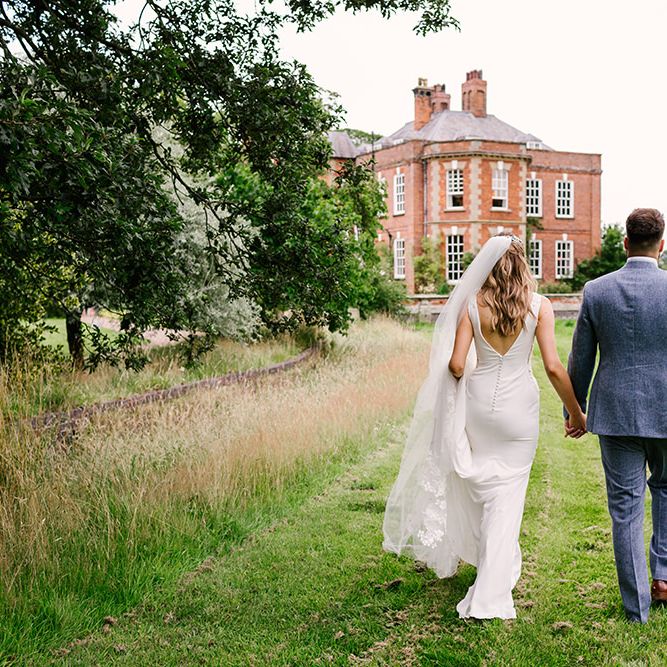 Bride in a Fitted Pronovias Wedding Dress with Button Back and Groom in Light Grey Wedding Suit