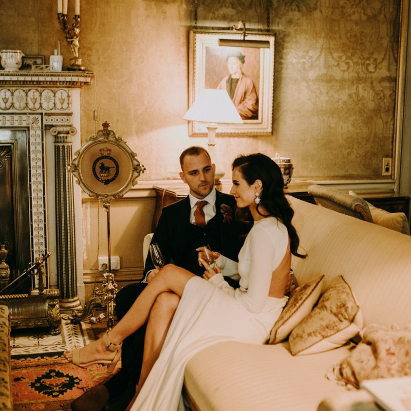 Bride and Groom Relaxing on The Sofa Showing Bride Split  Design in Her Dress