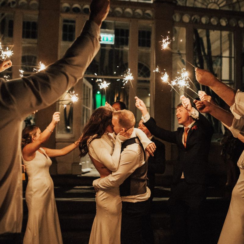 Bride and Groom Kissing During Sparkler Moment