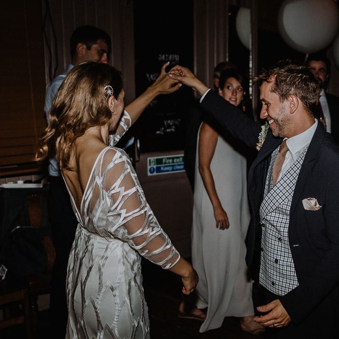 Bride in Embroidered Tulle Halfpenny London Dress with High Neckline, Batwing Sleeves and Low V Back | Anthropologie Hairpiece | Groom in Navy Slim Fit Suit with Checked Double Breasted Waistcoat and Blush Pink Knitted Tie | First Dance | Wedding Reception at The Star Pub, Highgate | Floral Arch and Bride in Batwing Sleeve Halfpenny Dress for London Pub Wedding | Caitlin + Jones