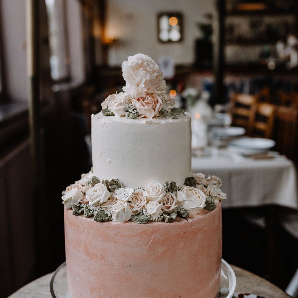 Two Tier Wedding Cake with Buttercream Icing and Iced Flowers | Floral Arch and Bride in Batwing Sleeve Halfpenny Dress for London Pub Wedding | Caitlin + Jones