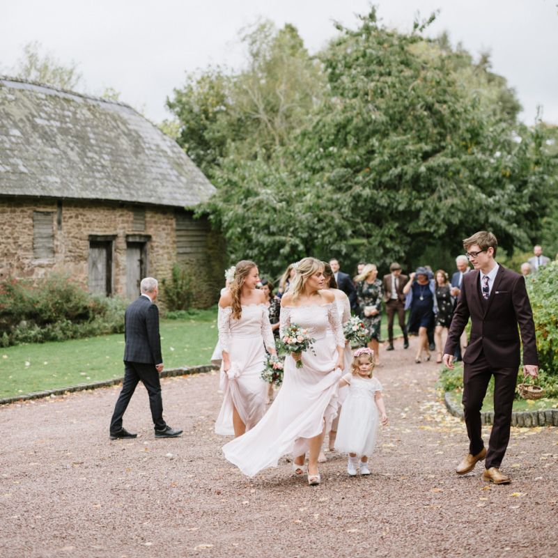 Wedding Party Walking Across The  Venue Courtyard