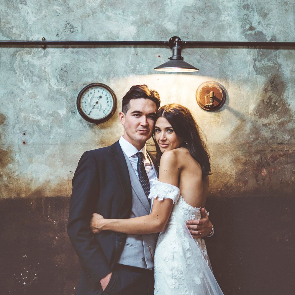 Bride in Fishtail Pronovias Wedding Dress with Off Shoulder Sleeves and Veil Cape | Groom in Navy Tails and Grey Waistcoat | Bride Wearing Hair Down | Lace Bridal Cape Veil &amp; Fishtail Wedding Dress by Pronovias | On Love and Photography