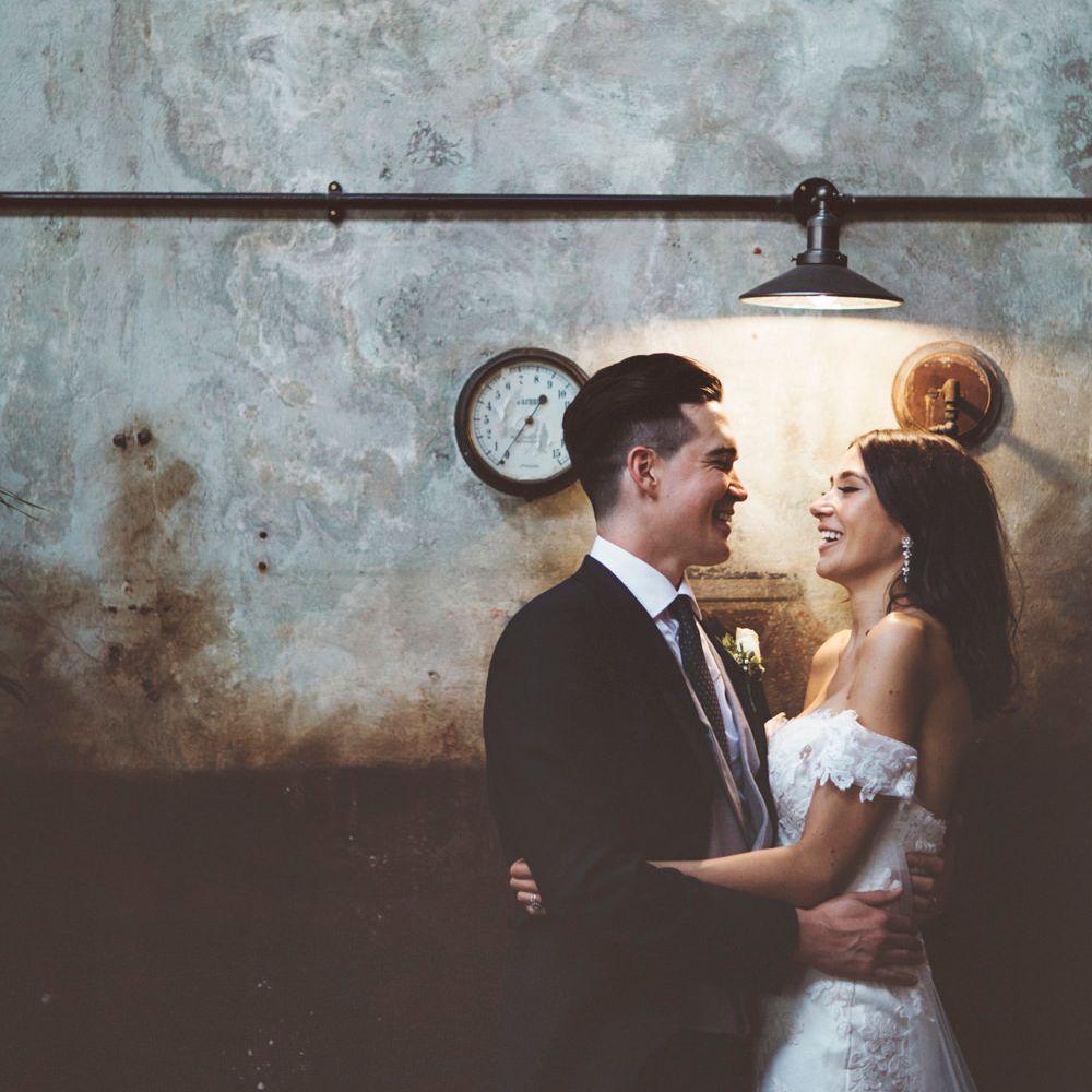 Bride in Fishtail Pronovias Wedding Dress with Off Shoulder Sleeves and Veil Cape | Groom in Navy Tails and Grey Waistcoat | Bride Wearing Hair Down | Lace Bridal Cape Veil &amp; Fishtail Wedding Dress by Pronovias | On Love and Photography