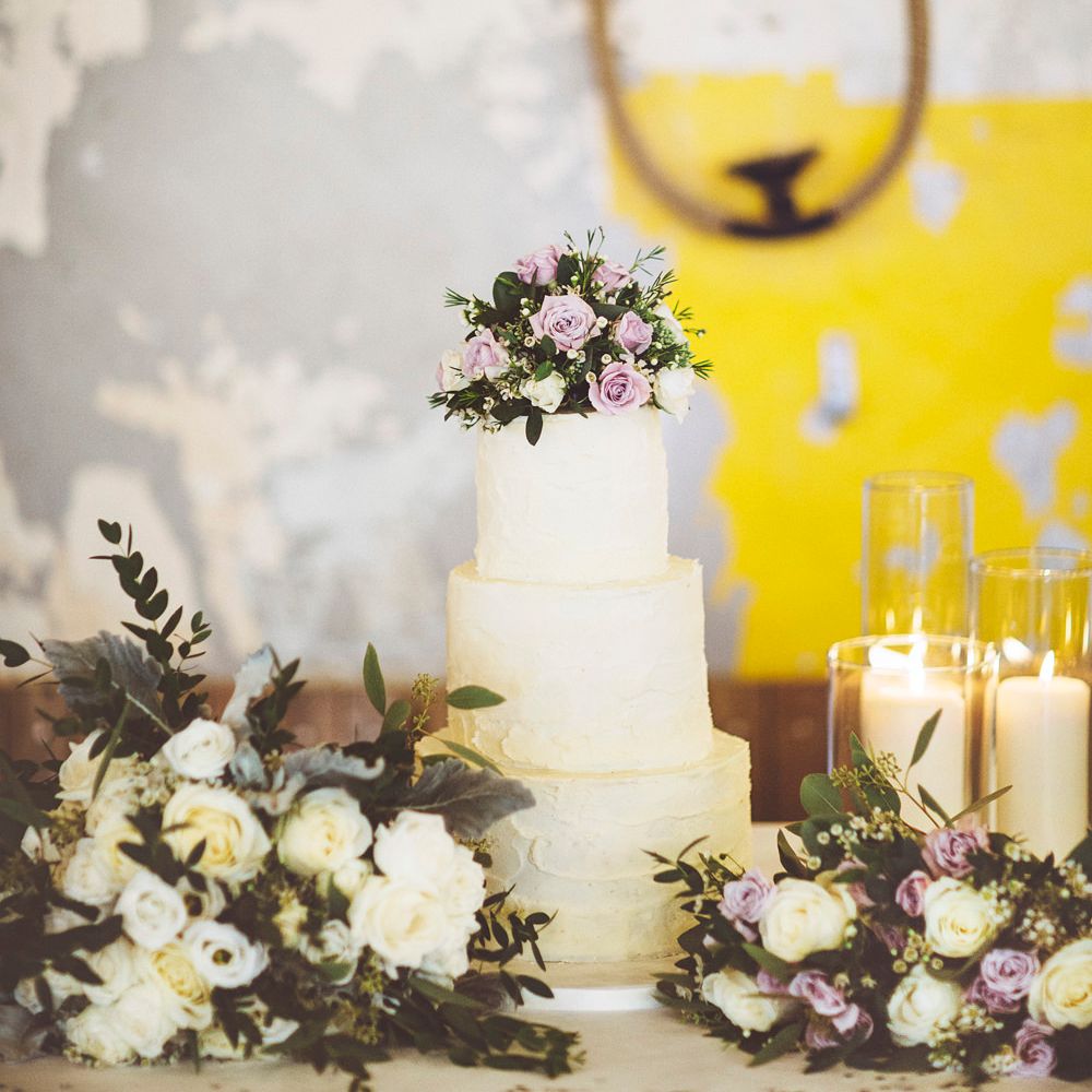 Three Tier Wedding Cake with Buttercream Icing | Bouquet of White Roses and Greenery | Bouquet of Dusky Purple Roses and Greenery | Pillar Candles | Lace Bridal Cape Veil &amp; Fishtail Wedding Dress by Pronovias | On Love and Photography