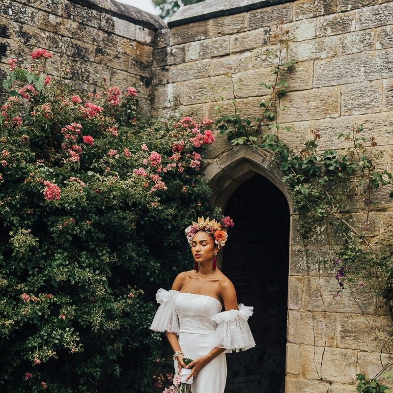 Beautiful bride in strapless wedding dress with tulle sleeves in flower crown