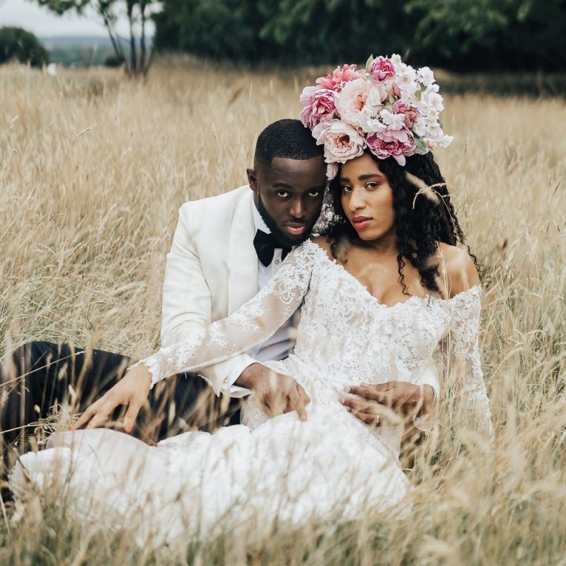 Bride and groom sitting in a field