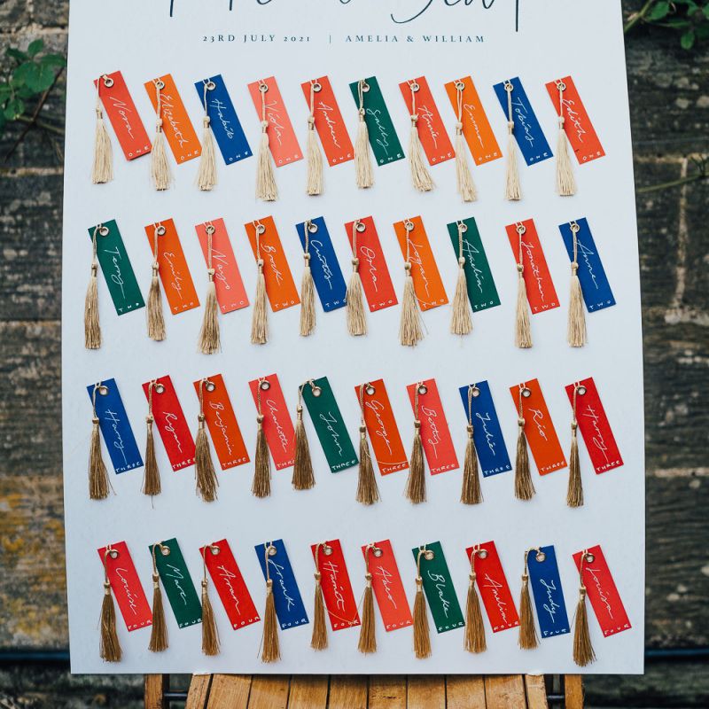 colourful escort card display with tassels by Aimee Willow Designs