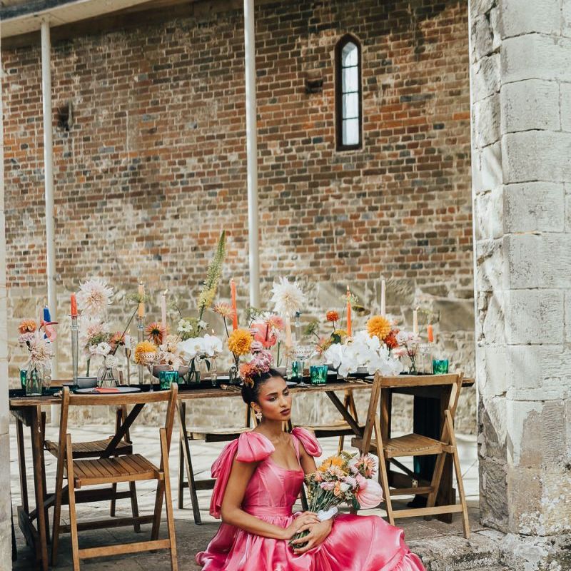 black bride sitting by the outdoor tablescape at Chiddingstone Castle