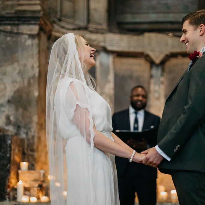 Bride and  groom say 'I do' at London celebration with candle light backdrop