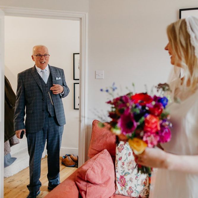 Bride wearing a lace edge veil with a bright bouquet for a colourful and fun day