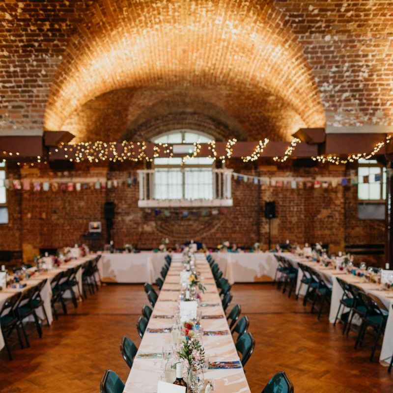 Reception styling for colourful and fun day with pine cone wedding decor