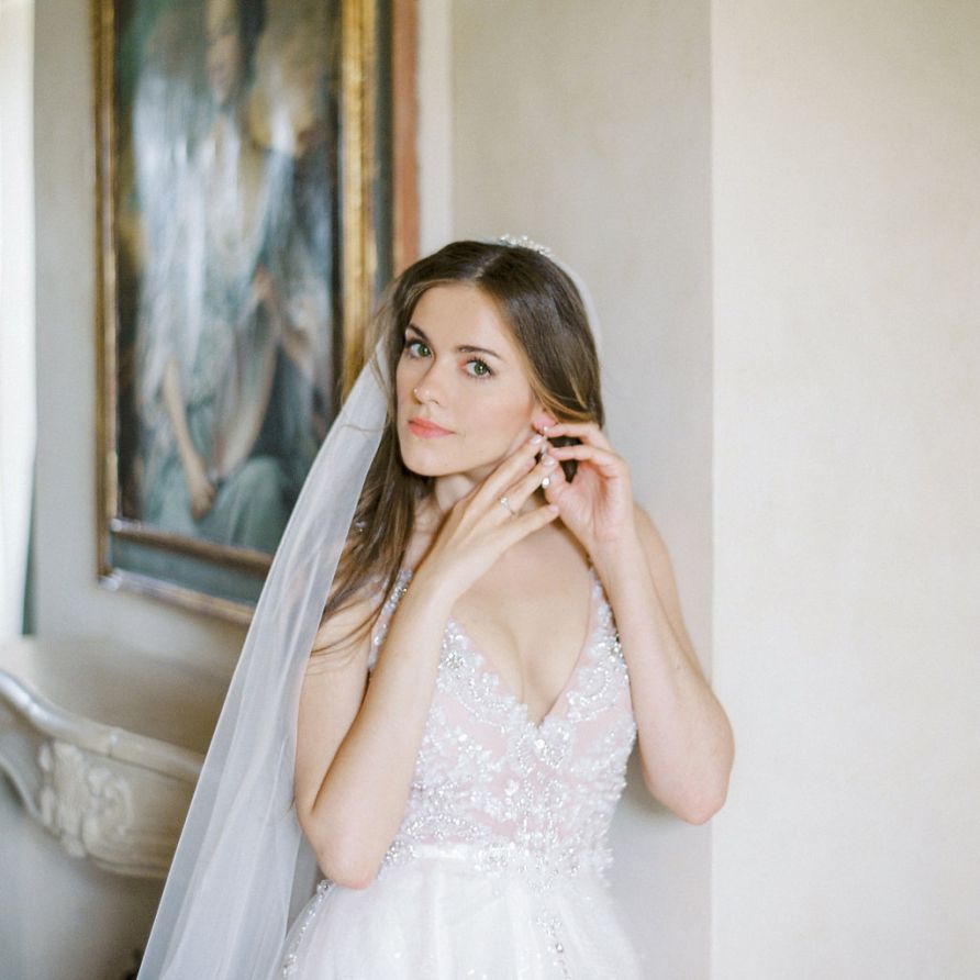 Beautiful Bride Putting on Her Wedding Day Earrings