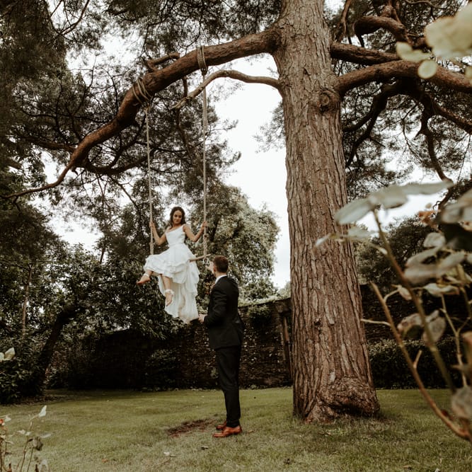 Bride swinging on a trapeze in homemade wedding dress
