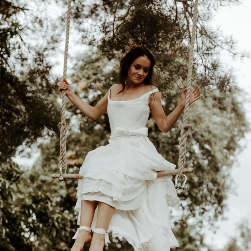Bride swinging on a trapeze in high low wedding dress