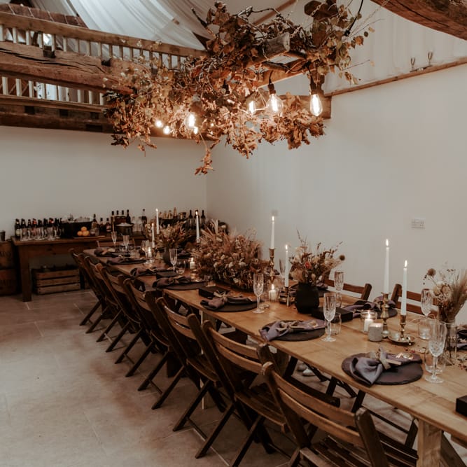 Intimate wedding reception  with Autumnal wedding decor and festoon lights