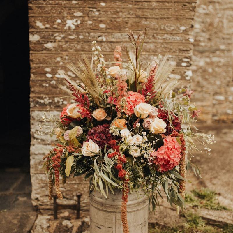 Rustic wedding flowers in milk churn