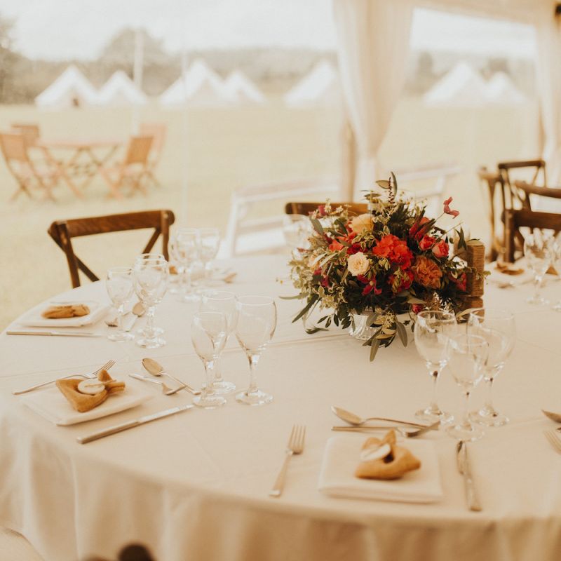 Rust coloured wedding flowers at marquee wedding with bride wearing Eliza Jane Howell wedding dress